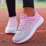 Baskets orthopédiques de sport chic pour femme portées par une femme avec un pantalon noir sur un terrain de course