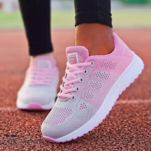 Baskets orthopédiques de sport chic pour femme portées par une femme avec un pantalon noir sur un terrain de course