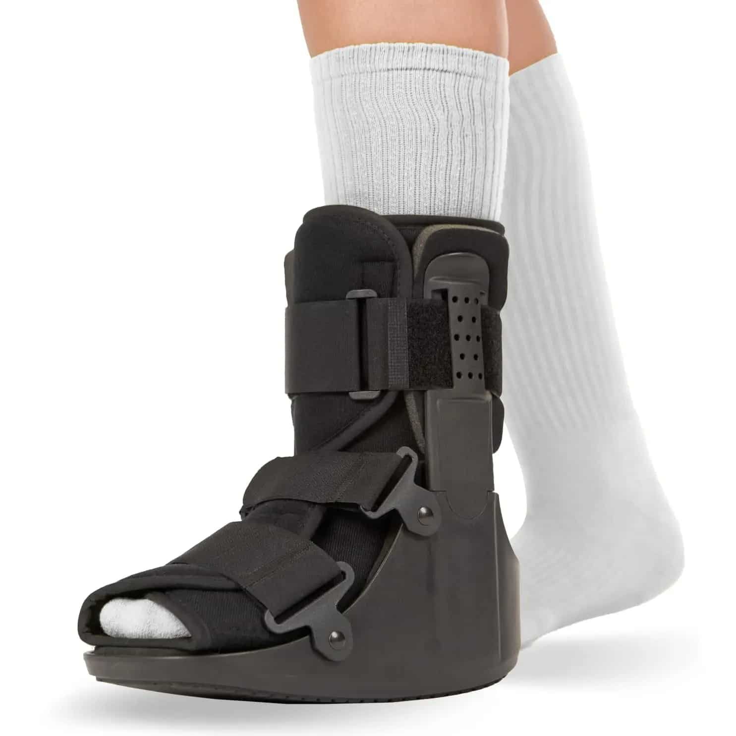 Botte de marche orthopédique et ajustable femme portée par une personne avec des chaussettes sur fond blanc