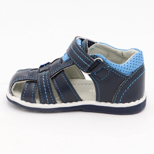 Chaussure bébé orthopédique bleue et noire sur fond gris