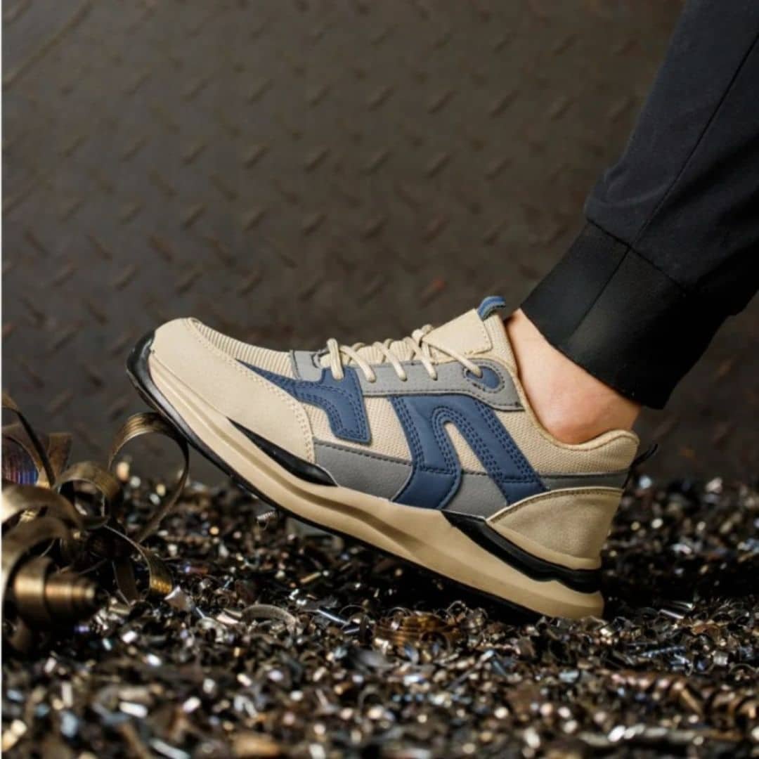 Chaussure sécurité orthopédique beige à lacets sur le pied d'une personne