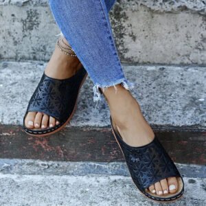 Sandales orthopédiques pour femme avec motif floral portées par une femme avec un jean bleu