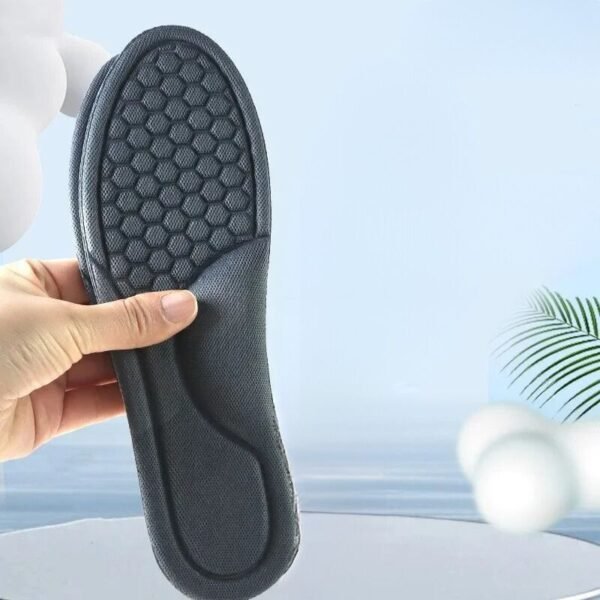 Semelles pour homme orthopédiques et respirantes tenues par une personne sur fond bleu